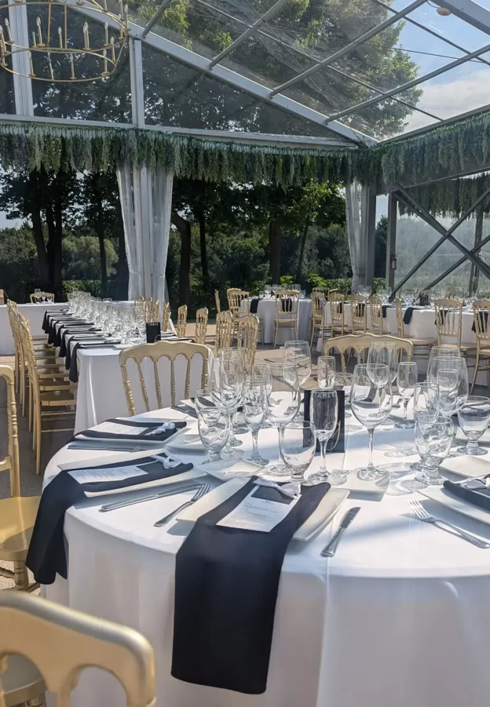 Outdoor wedding catering dining area set up under glass covering